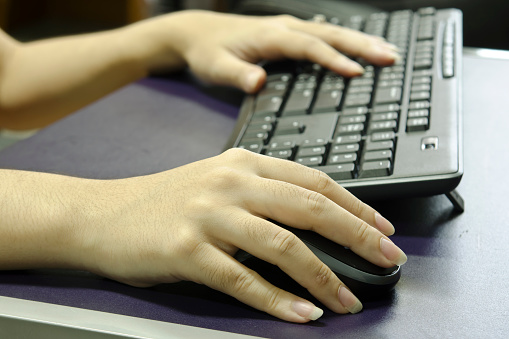 Woman hands work on mouse and keyboard