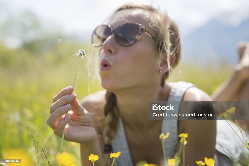 Jeune femme souffle sur Fleur - Photo de Adulte libre de droits