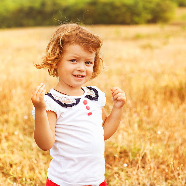 Little girl running on meadow with sunset