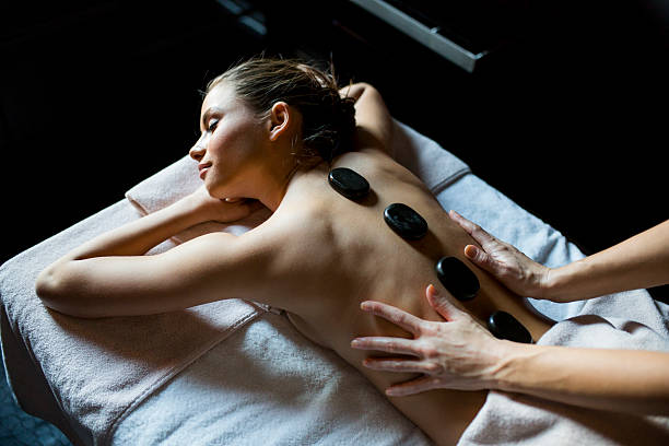 istock Young woman having a hot stone massage therapy 488597052