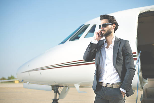 istock Businessman with smart phone next to private jet 488597178