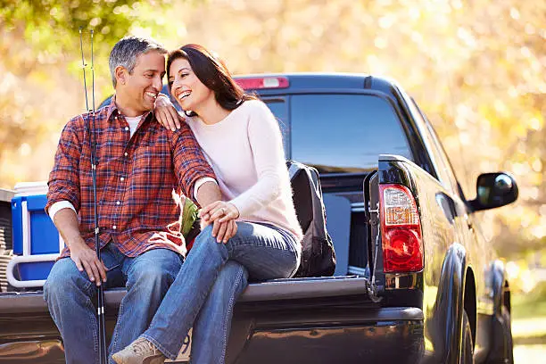 Photo of Couple Sitting In Pick Up Truck On Camping Holiday