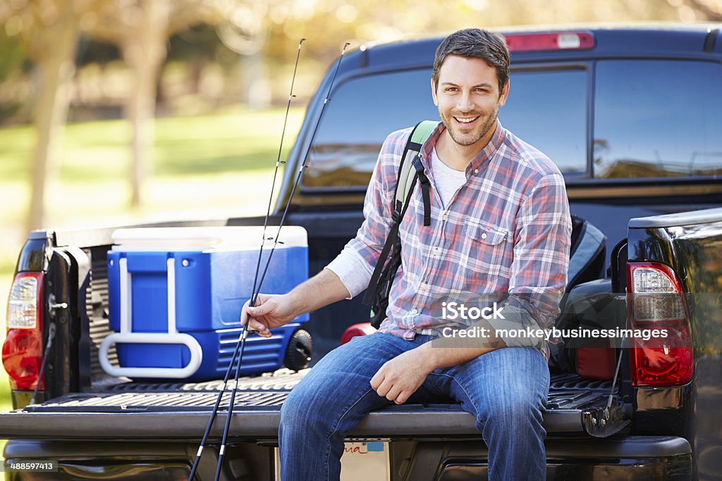 Homem sentado na Caminhonete no Acampamento de Férias - Foto de stock de Caminhonete pickup royalty-free