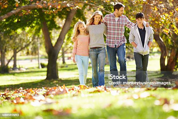 Familia De Cuatro Pasos En Otoño Las Hojas En El Parque Foto de stock y más banco de imágenes de Cuatro personas