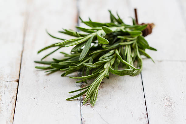 istock Fresh rosemary on wooden background 488599031
