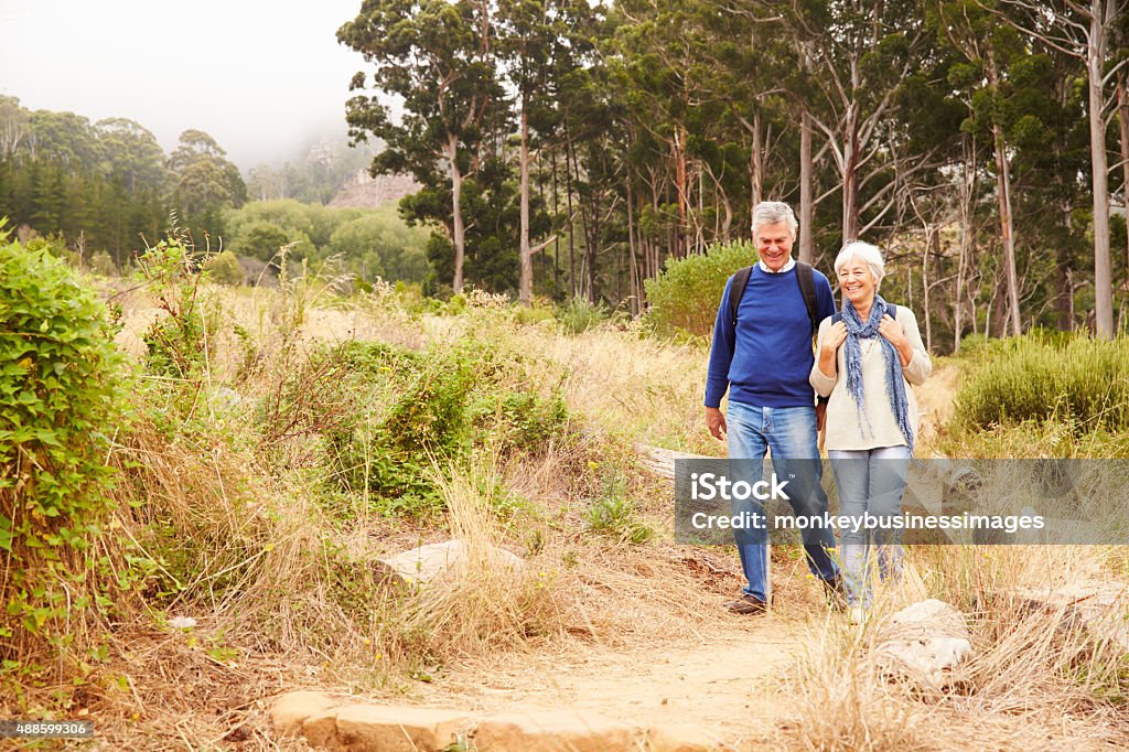 Senior Pareja caminando en un bosque hacia la cámara - Foto de stock de Camino libre de derechos
