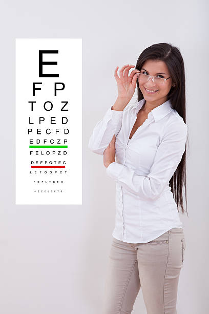 istock Woman pointing standing next to an eye chart 488600424