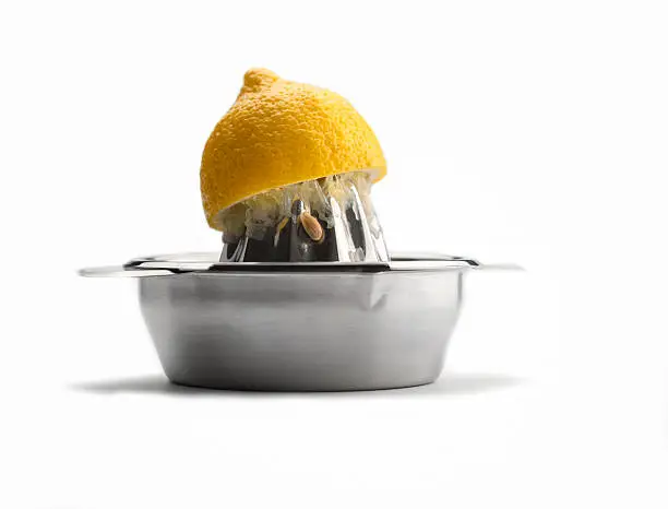 Kitchen Utensils: Citrus Squeezer, chrome citrus juicer with  one ripe yellow lemon pressed on the squeezer,isolated on white