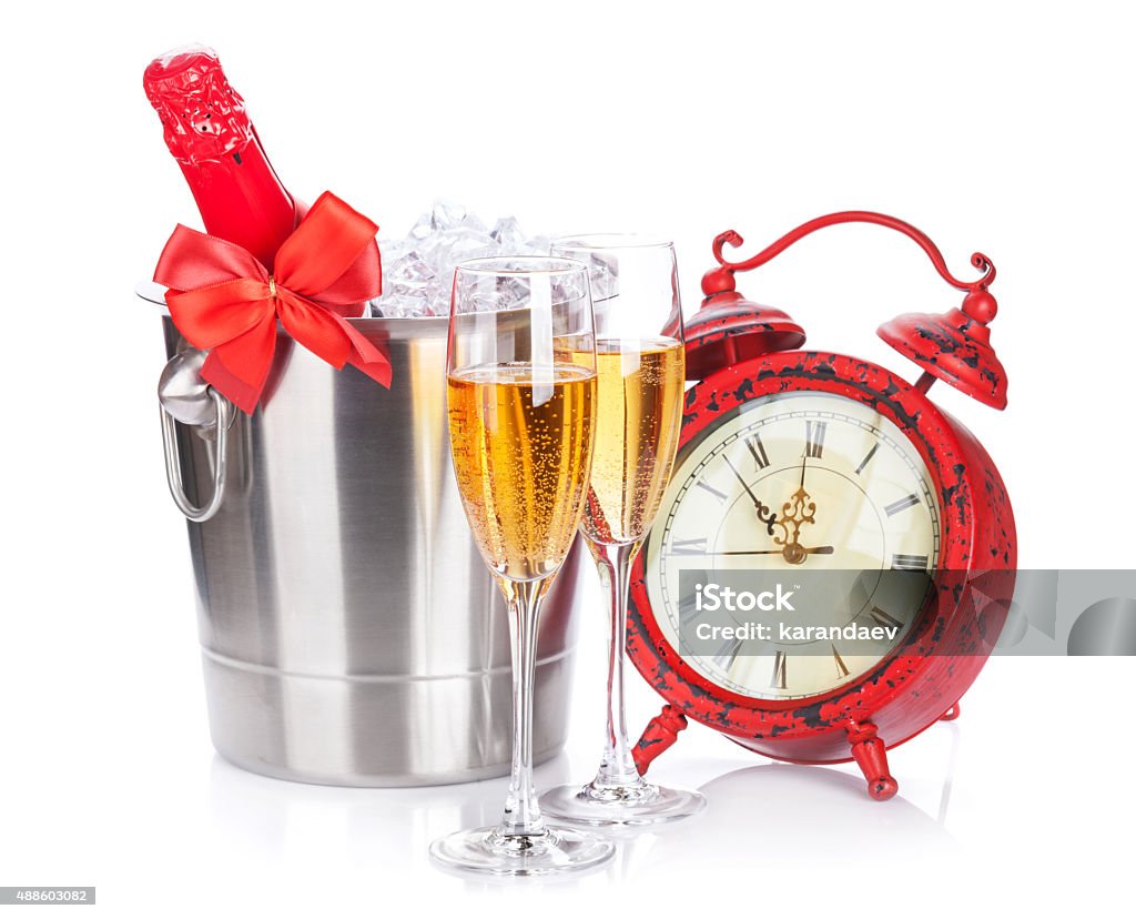 Two champagne glasses, bottle in cooler and clock Two champagne glasses, bottle in cooler and clock. Isolated on white background 2015 Stock Photo