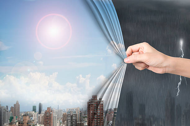 Woman hand pulling sunny sky cityscapes curtain covering stormy stock photo