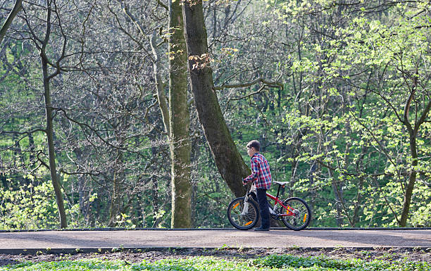 istock Young boy with bike in park 488612454