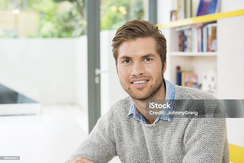 Young Man Smiling At Home Portrait of relaxed young man smiling at home 20-29 Years Stock Photo