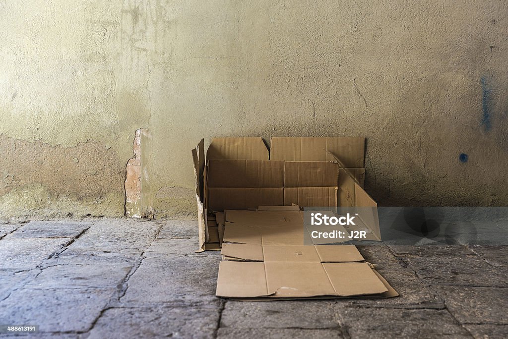 Bed made of cartons of a homeless man Bed made of cartons of a homeless man on a street covered with old stone floor of the old town of Barcelona. Homelessness Stock Photo