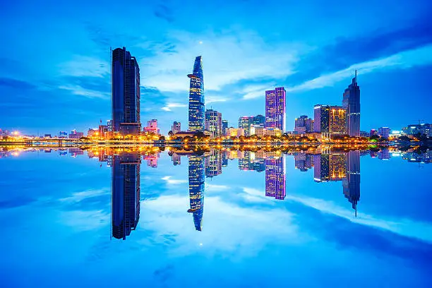 Reflection of Night view of Business District and Administrative Center of Ho Chi Minh city on Saigon riverbank.