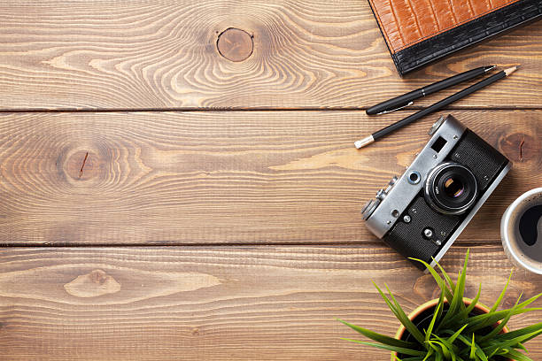 istock Camera and supplies on office wooden desk 488614132