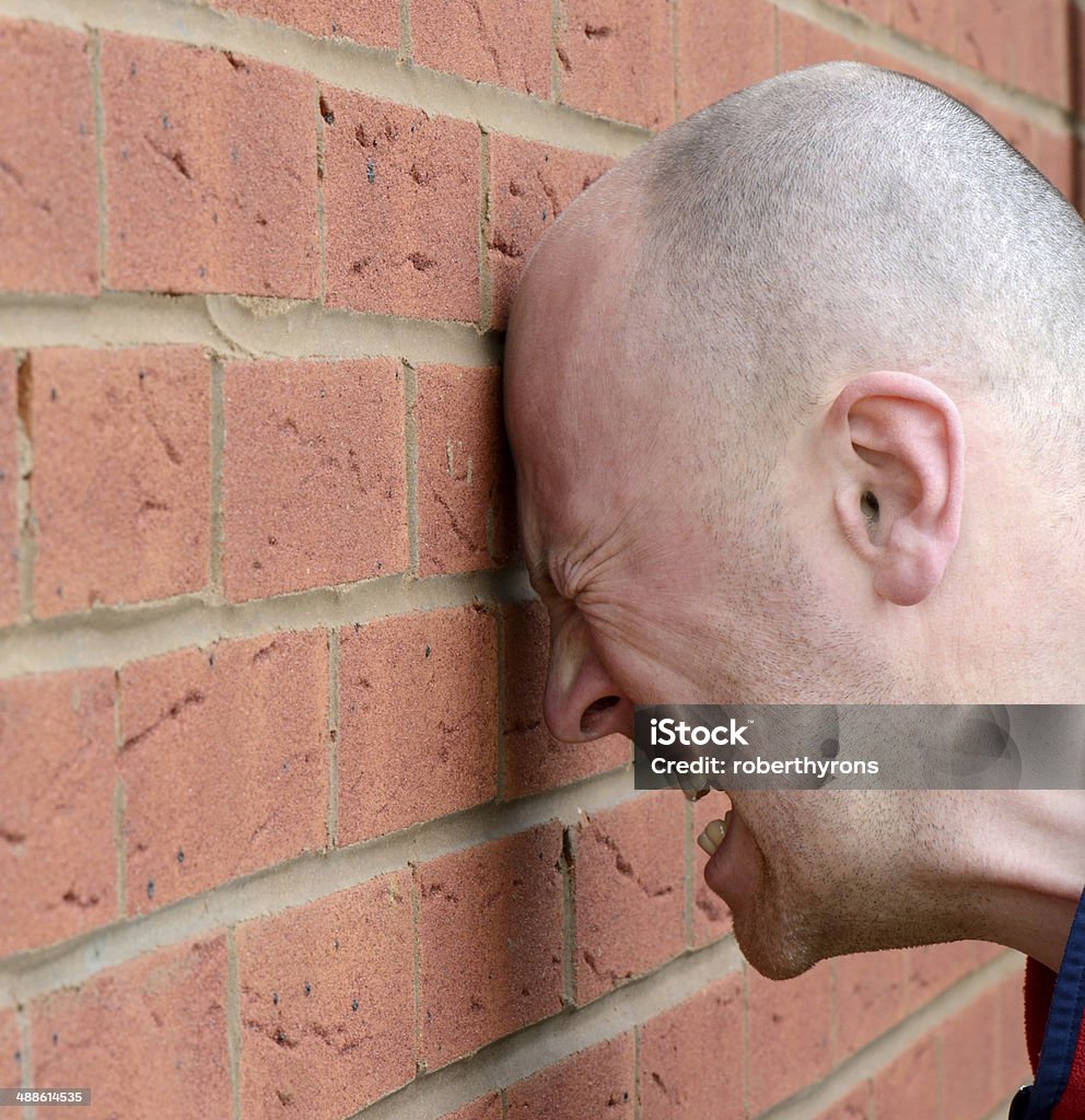 head banging a man banging his head agaist the wall in frustration Hitting Stock Photo