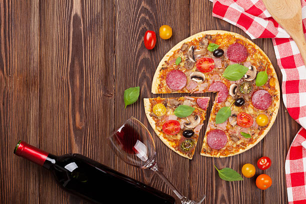 istock Italian pizza with pepperoni, tomatoes, olives, basil and red wi 488614648