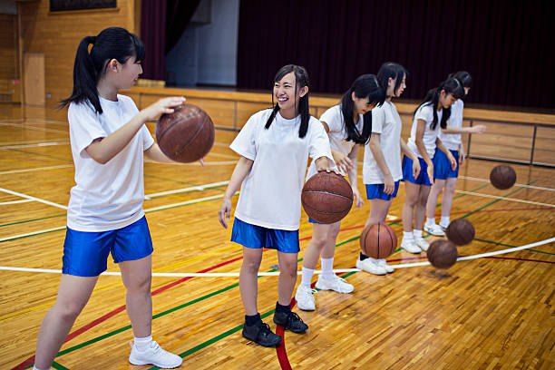 japanische mädchen sportarten wie basketball in der sporthalle - school gymnasium gym basketball court school stock-fotos und bilder