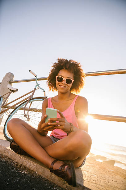 istock Smiling Girl texting near beach 488615075