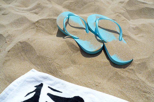istock Flip flops and towel on the beach 488615173