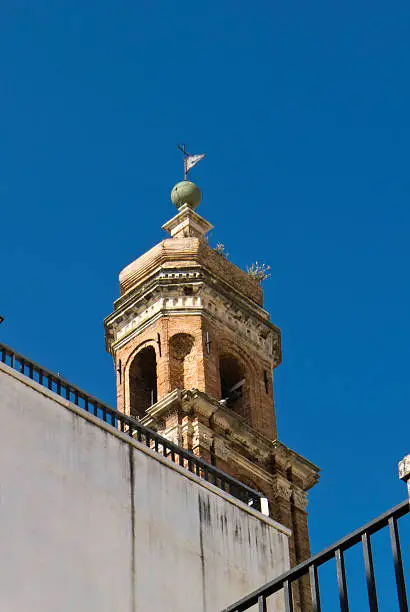 Bell tower soars in clear sky, spire Byzantine style.
