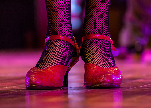 Female tango dancer wore up red shoes close up
