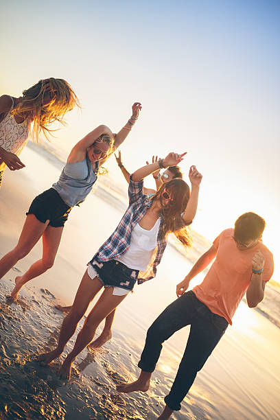 istock Friends dancing on beach in sunset 488617337