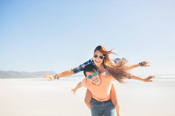 istock Couple piggyback on beach 488617839