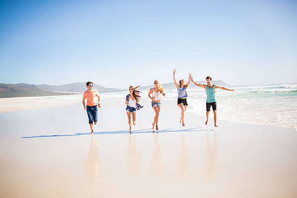 istock Friends running along the beach 488617895