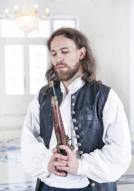 istock Young handsome man in medieval clothes with pistol 488623580