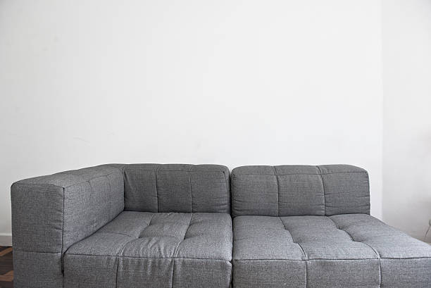 istock Gray modern sofa in empty room with white walls 488625372