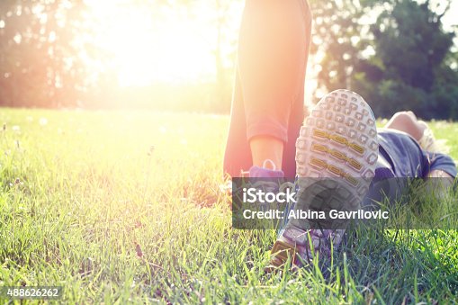 istock Woman lying down on grass and  relaxing after workout. 488626262