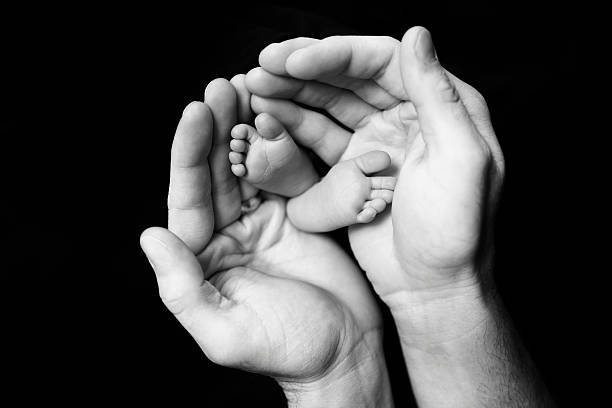 istock Newborn Feet in Father's Hands 488626964