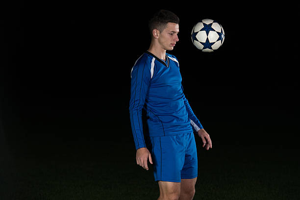 istock Professional Soccer Player Kicking Ball Isolated On Black 488638310