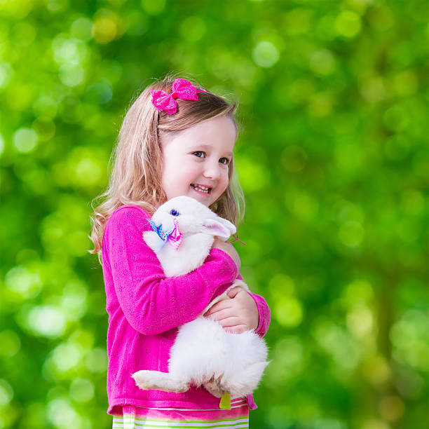 istock Little girl playing with rabbit 488638616