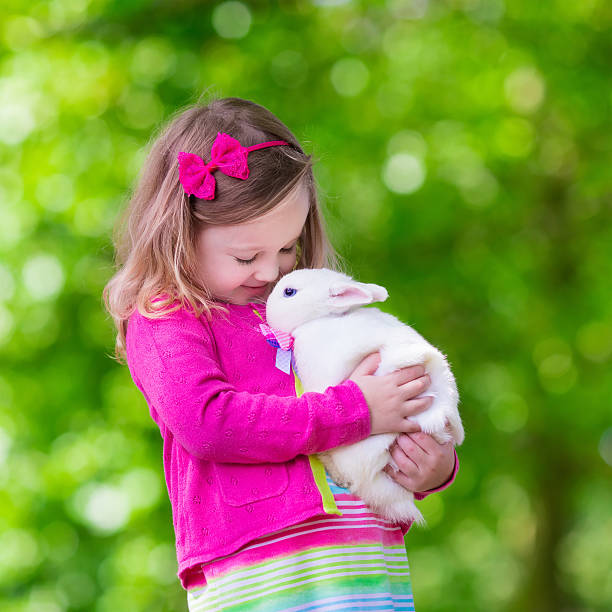 istock Little girl playing with rabbit 488638746