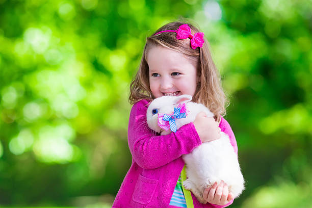 istock Little girl playing with rabbit 488638882