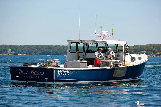 Lobster boat and two lobstermen stock photo