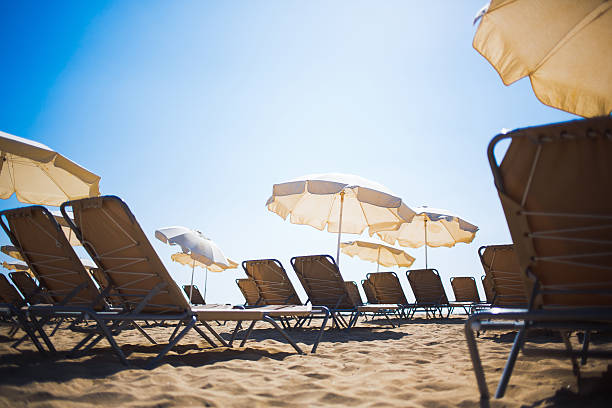 istock Free deck chairs and sun umbrellas on a beach 488640136