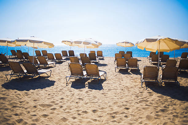 istock Sun-beds and umbrellas on coastline near sea 488640184