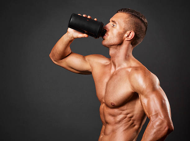 Muscular man with protein drink in shaker Muscular man with protein drink in shaker bodybuilding supplement stock pictures, royalty-free photos & images