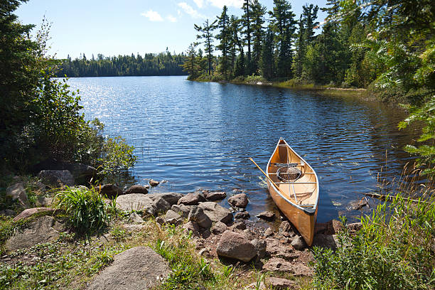 fisherman's canoe on rocky shore en el norte de minnesota lago - canoeing canoe minnesota lake fotografías e imágenes de stock