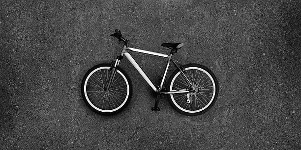 bicicleta deitada pavimento, de bicicleta no asfalto velocipede superfície cinzento - bicycle chain bicycle tire black and white imagens e fotografias de stock