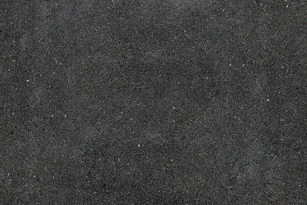 Real asphalt texture background. Coloured dark black asphalt pattern. Grainy street detail gray textured background. Best way show your design or illustration with this actual asphault photo texture.