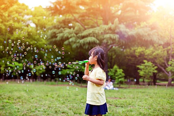 istock Little girl blowing soap bubbles 488649306