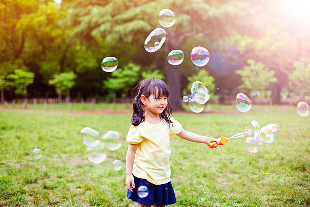 istock Little girl blowing soap bubbles 488649454