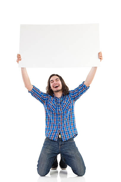 istock Smiling young man holding a placard 488651897