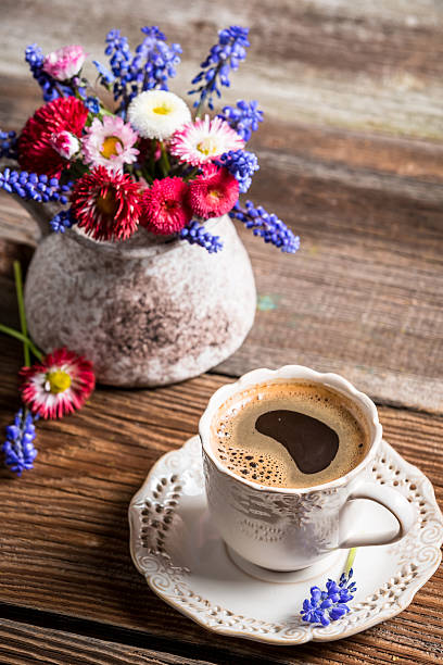 istock Coffee and spring flowers on old wooden table 488654297