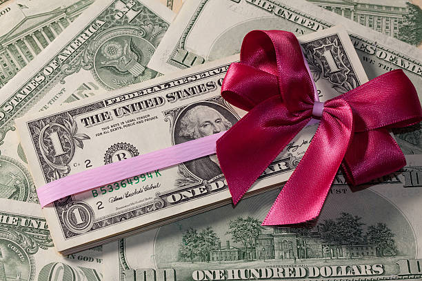 istock Pack of dollar bills with red bow 488655083