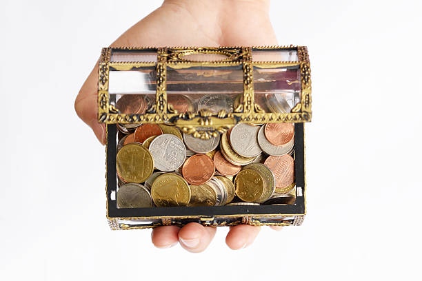 istock hand holding chest with gold coins on white background. 488659212